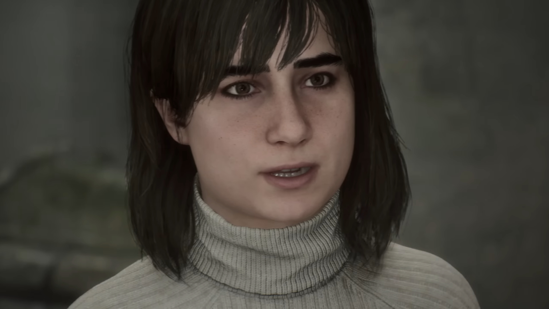 Das Gesicht einer Frau mit dunklen Haaren und in einem hellen Rollkragen-Pullover